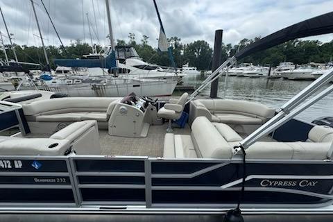 Cypress Cay Seabreeze 232 2023 Cypress Cay Seabreeze 232 pontoon boat docked at marina, featuring spacious seating.