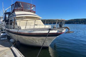 Kha Shing Sundeck 1984 Kha Shing Sundeck yacht docked by serene waters under clear blue sky.
