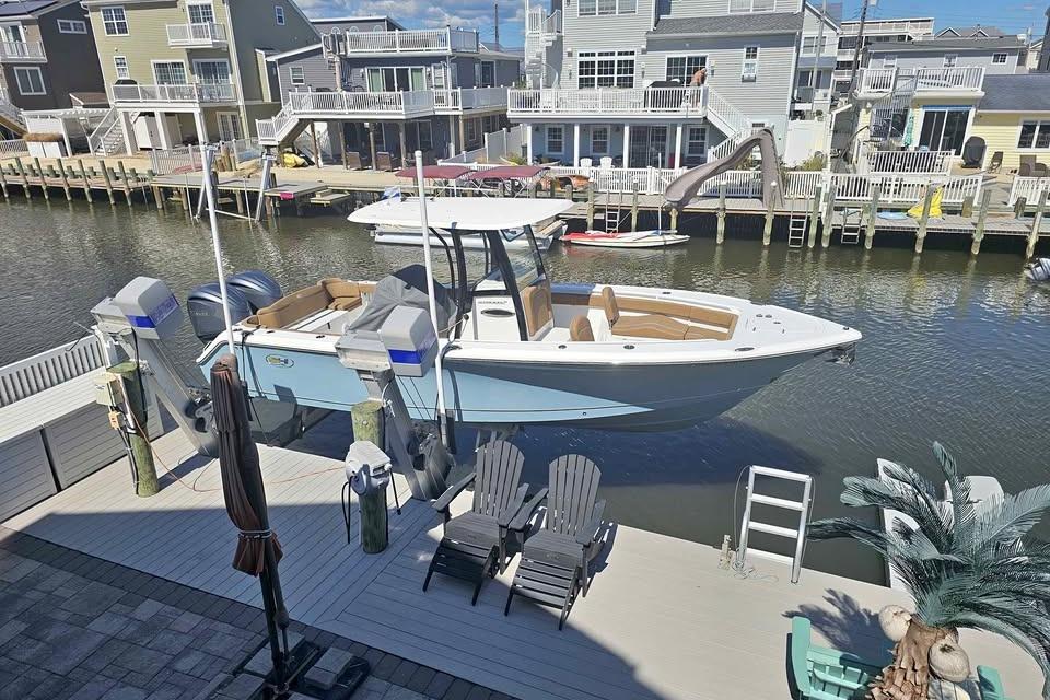 Sea Hunt Ultra 275 SE 2023 Sea Hunt Ultra 275 SE boat docked in a residential canal setting.