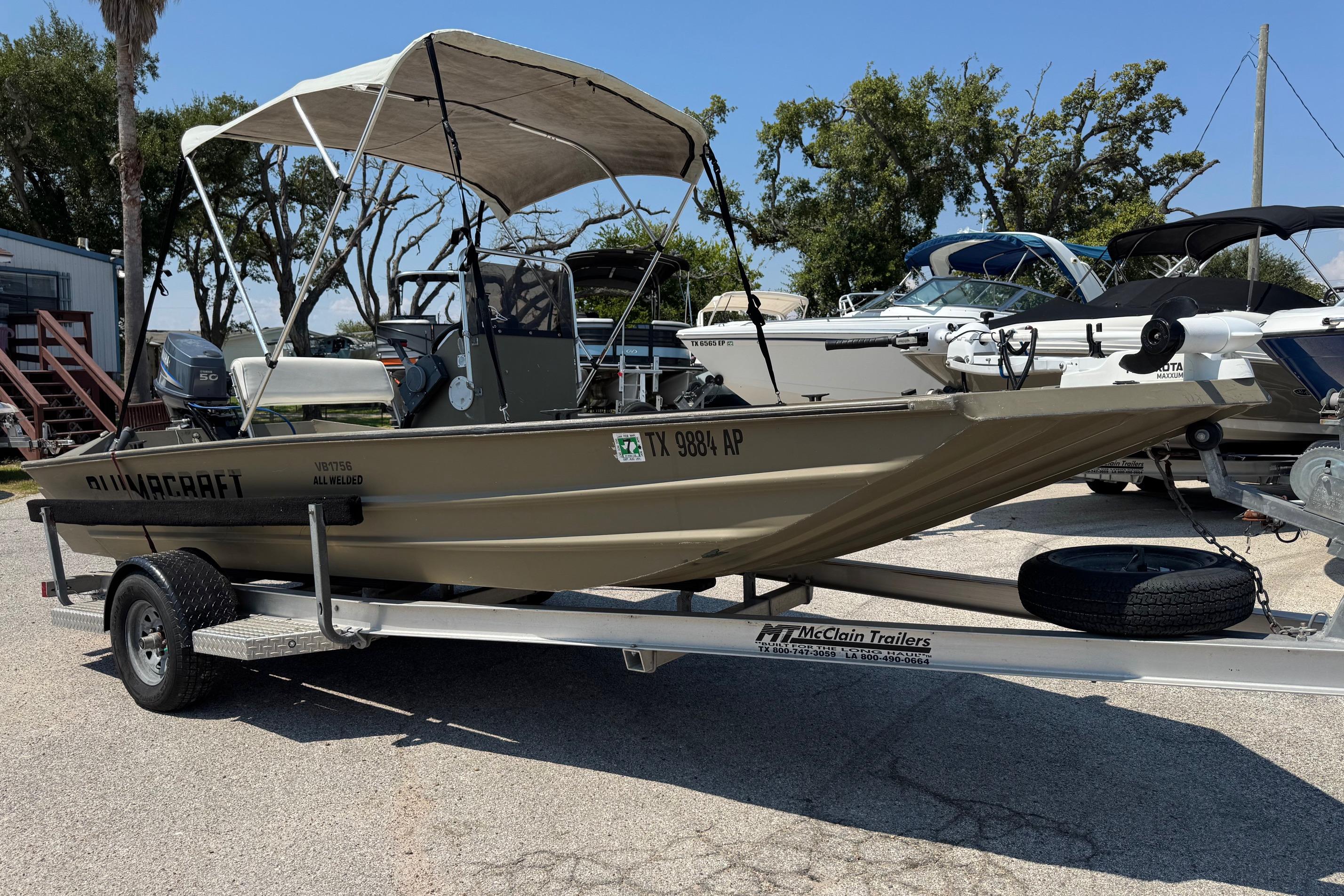 Alumacraft VB1756AW 2008 Alumacraft VB1756AW boat on trailer with canopy, parked outdoors.