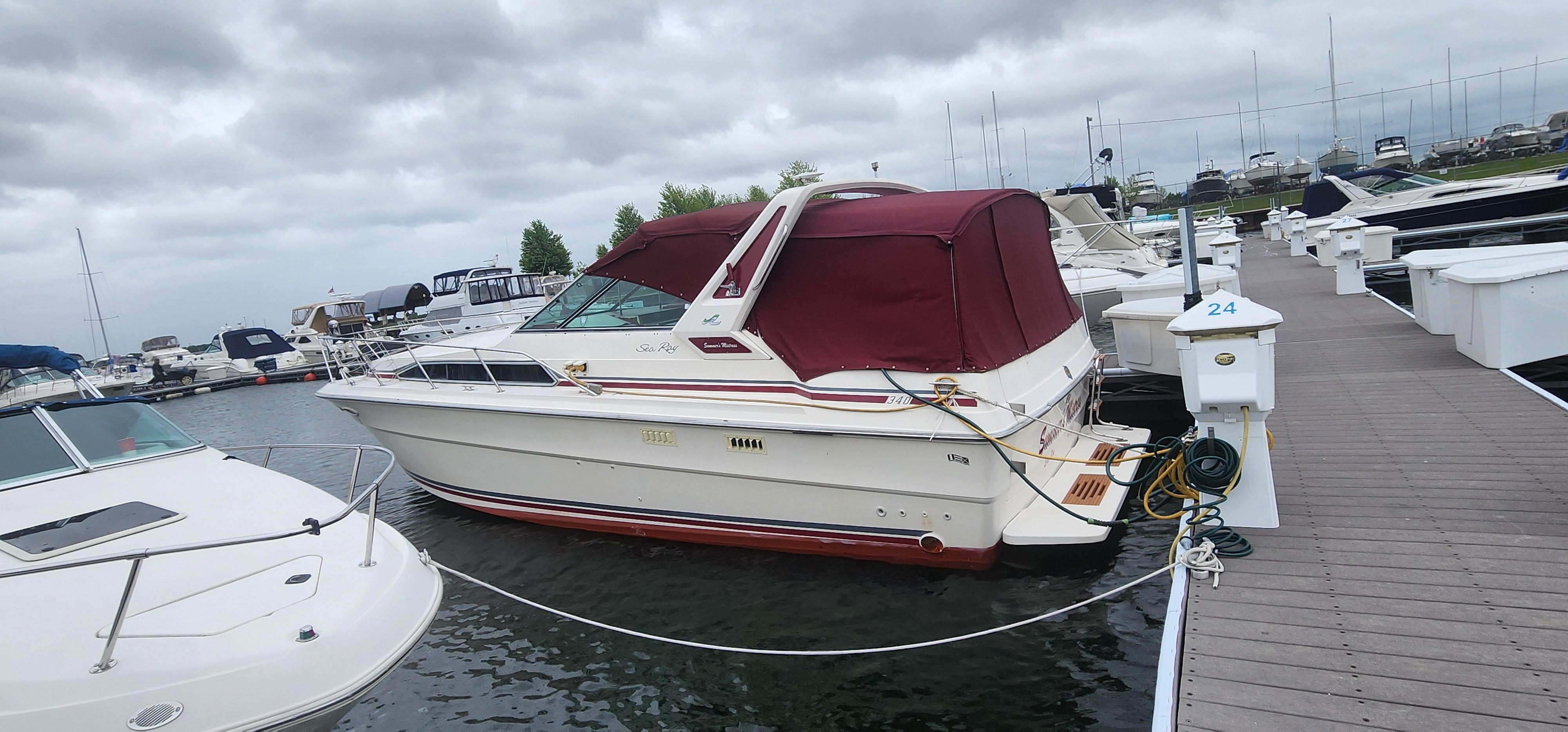 Sea Ray 36 Sundancer 1987 Sea Ray 36 Sundancer docked at marina with maroon canopy.