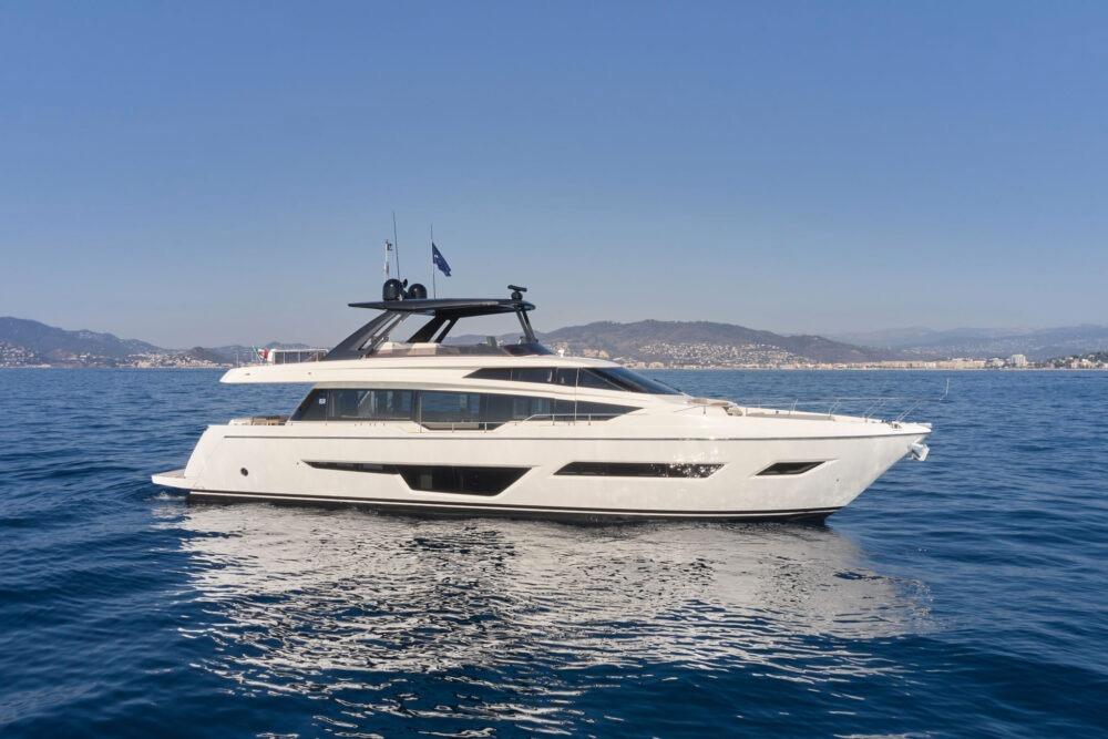 Ferretti Yachts 780 2024 Ferretti 780 yacht cruising on calm blue waters with scenic coastal backdrop.