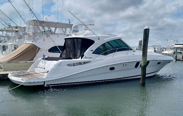 Sea Ray 48 Sundancer 2006 Sea Ray 48 Sundancer yacht docked in a marina under cloudy skies.