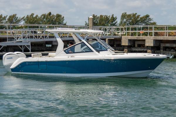 Edgewater 262 CX 2025 Edgewater 262 CX boat on water, blue and white design, dock in background.