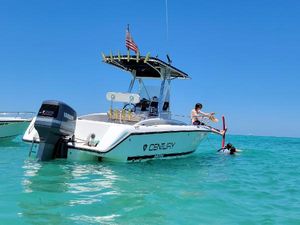 Century 2300 Center Console Century 2300 Center Console boat, 2001 model, on clear blue water with people enjoying the sun.