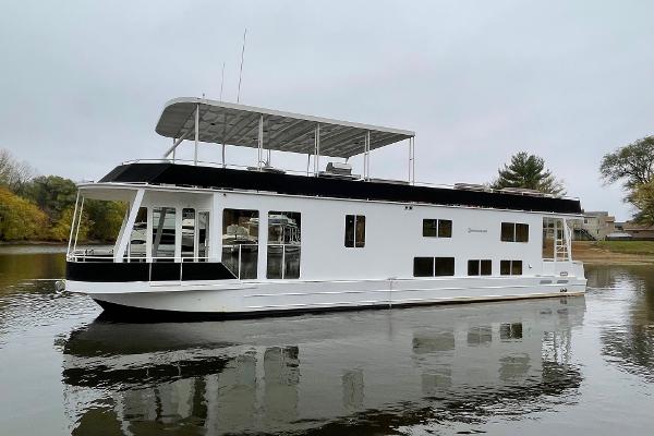 Skipperliner 640 2007 Skipperliner 640 houseboat on calm water, featuring a sleek white and black design.