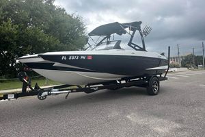 Axis A20 2012 Axis A20 boat on trailer, parked on road under cloudy sky.