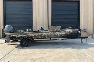 Ranger RT188 2015 Ranger RT188 boat with camouflage design on a trailer, parked outside a building.
