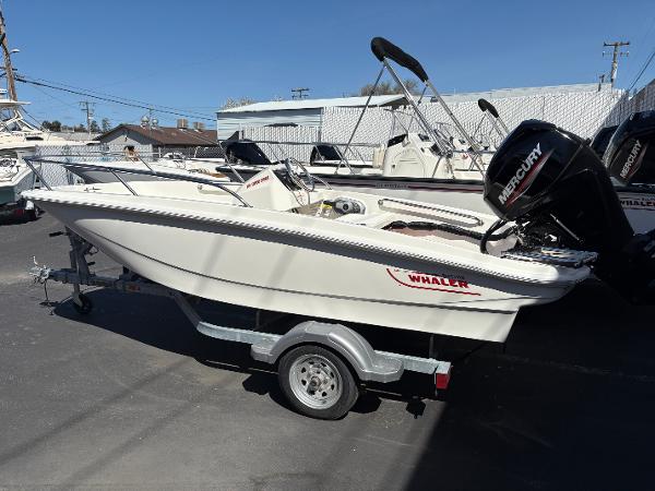 Boston Whaler 130 Super Sport 2025 Boston Whaler 130 Super Sport boat on trailer, featuring Mercury outboard motor.
