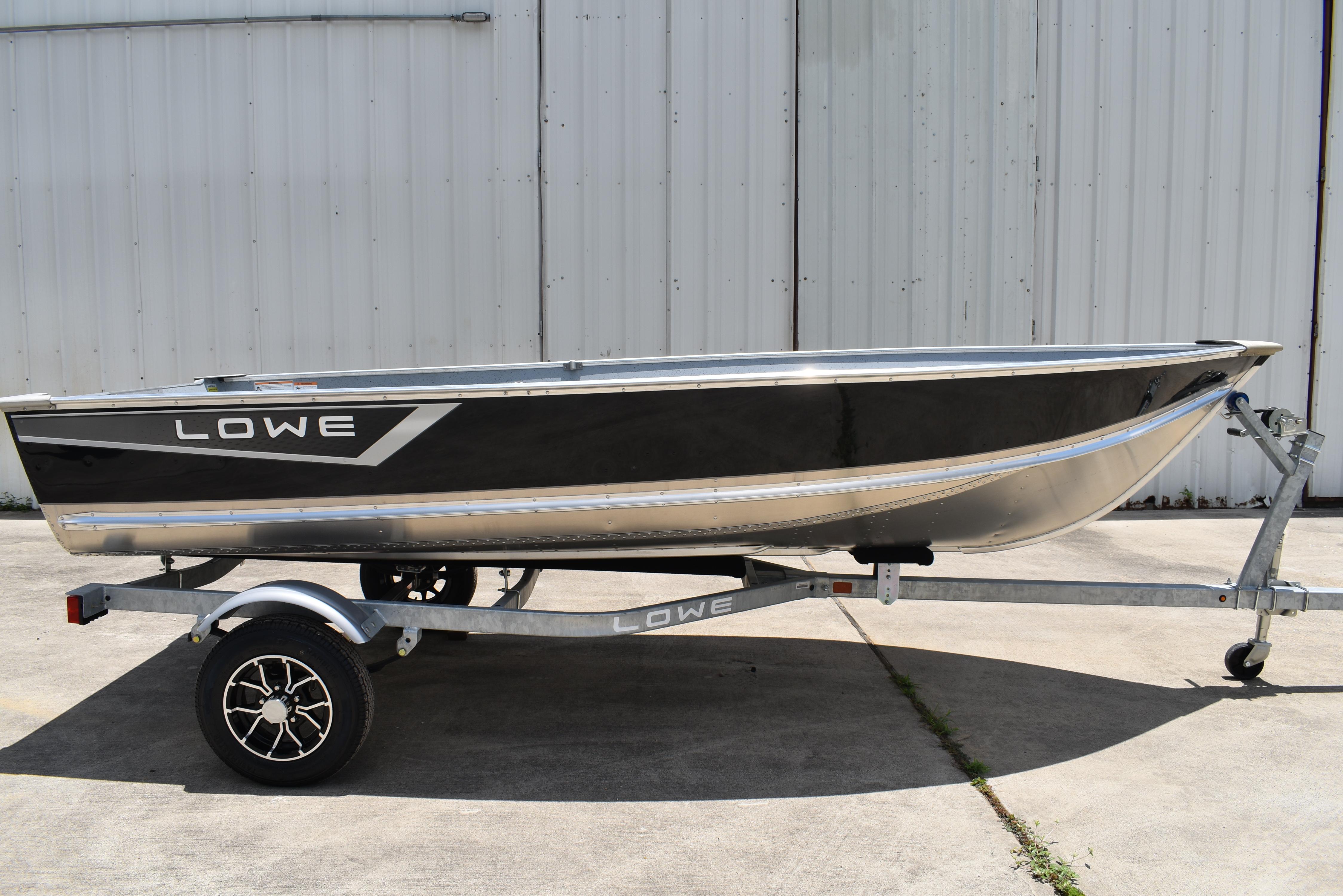 Lowe WV 1470 2024 Lowe WV 1470 boat on trailer, black and silver design, parked outdoors.