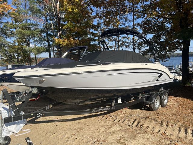 Chaparral 23 SSi 2025 Chaparral 23 SSi boat on trailer, surrounded by autumn trees near a lake.