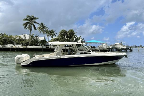 Boston Whaler 350 Realm 2019 Boston Whaler 350 Realm boat on water, with palm trees and docks in the background.
