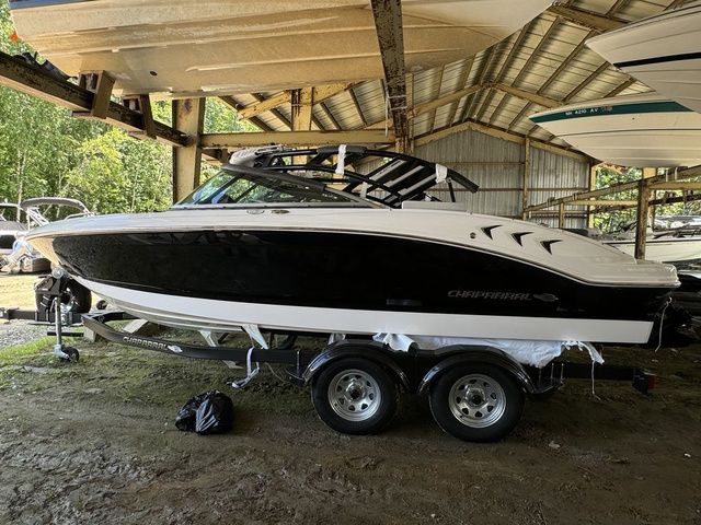 Chaparral 21 SSi 2025 Chaparral 21 SSi boat in storage, black and white design, on a trailer.