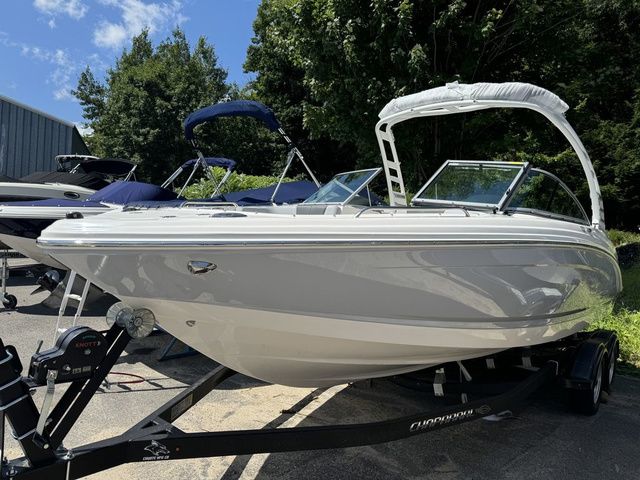Chaparral 23 SSi 2025 Chaparral 23 SSi boat on trailer, parked outdoors under clear blue sky.