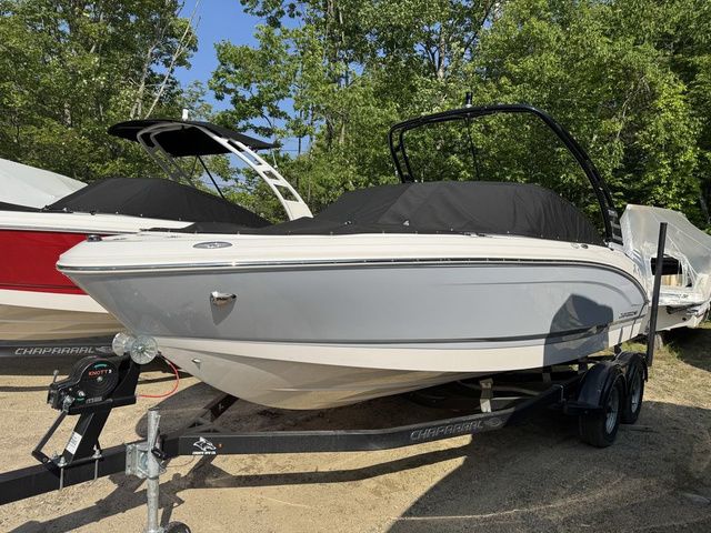 Chaparral 21 SSi 2025 Chaparral 21 SSi boat on trailer, covered, surrounded by trees.