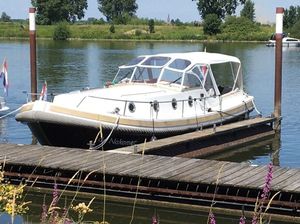 Pieterse Pieterse 10.50 Pieterse 10.50 boat docked on a serene river, surrounded by lush greenery.