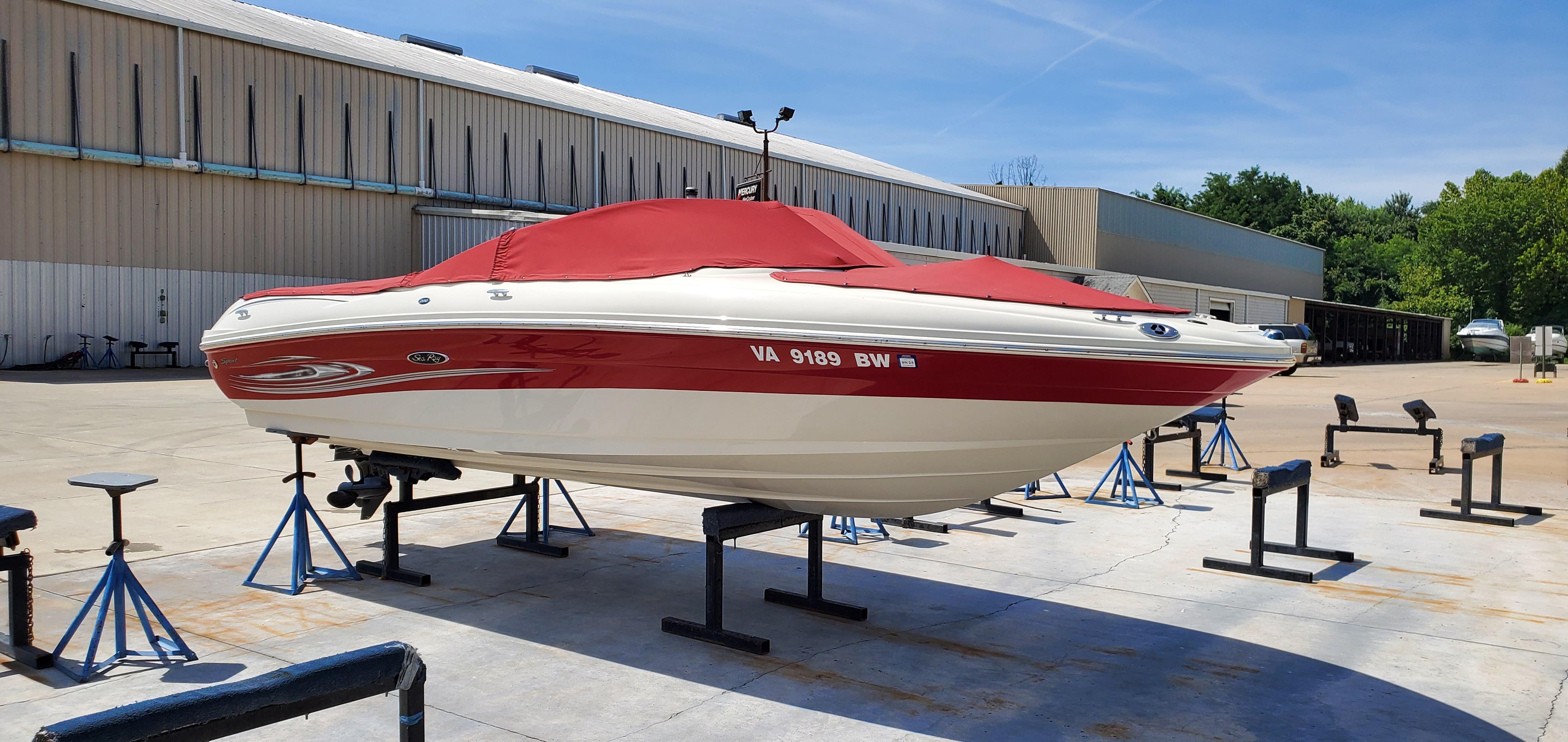 Sea Ray 200 Sport 2005 Sea Ray 200 Sport boat with red cover on stands in a marina.