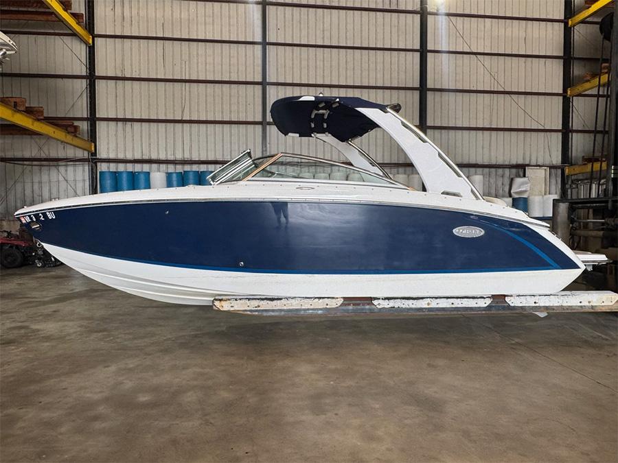 Cobalt R5 2014 Cobalt R5 boat in warehouse, blue and white exterior, side view.