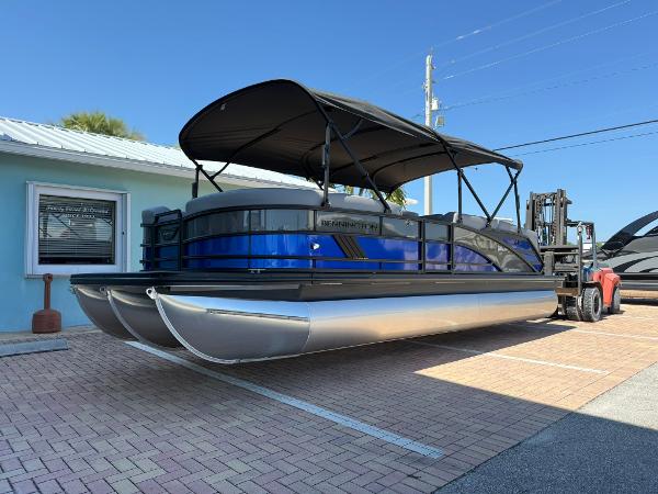 Bennington 24 MFB 2025 Bennington 24 MFB pontoon boat with blue accents, parked outdoors on a sunny day.