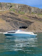 Bayliner VR6 Cuddy 2022 Bayliner VR6 Cuddy boat on water near rocky cliff.