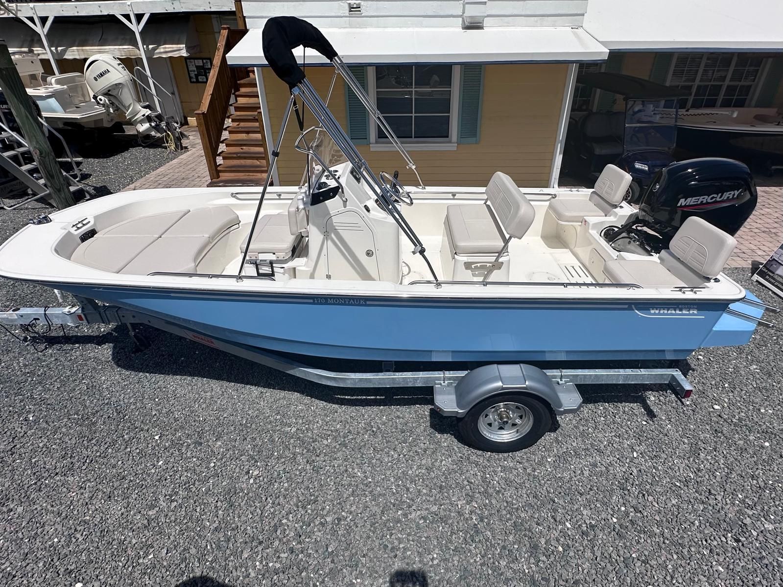 Boston Whaler 170 Montauk 2026 Boston Whaler 170 Montauk boat on trailer, featuring a sleek design and Mercury engine.