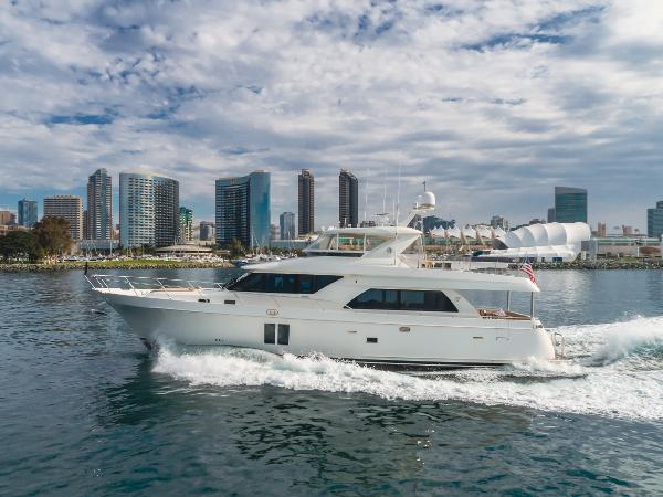 Ocean Alexander 72 2015 Ocean Alexander 72 yacht cruising near city skyline under cloudy sky.