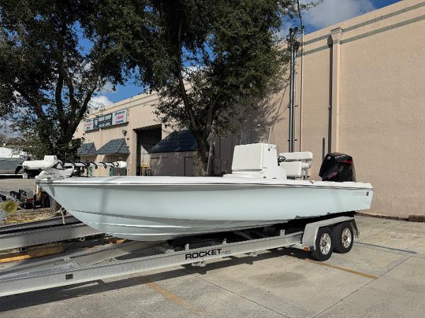 Contender 23 Bay 2025 Contender 23 Bay boat on trailer, parked outdoors near a building.