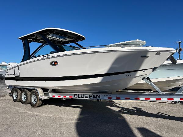 Chaparral 310 OSX 2025 Chaparral 310 OSX boat on trailer under clear blue sky.