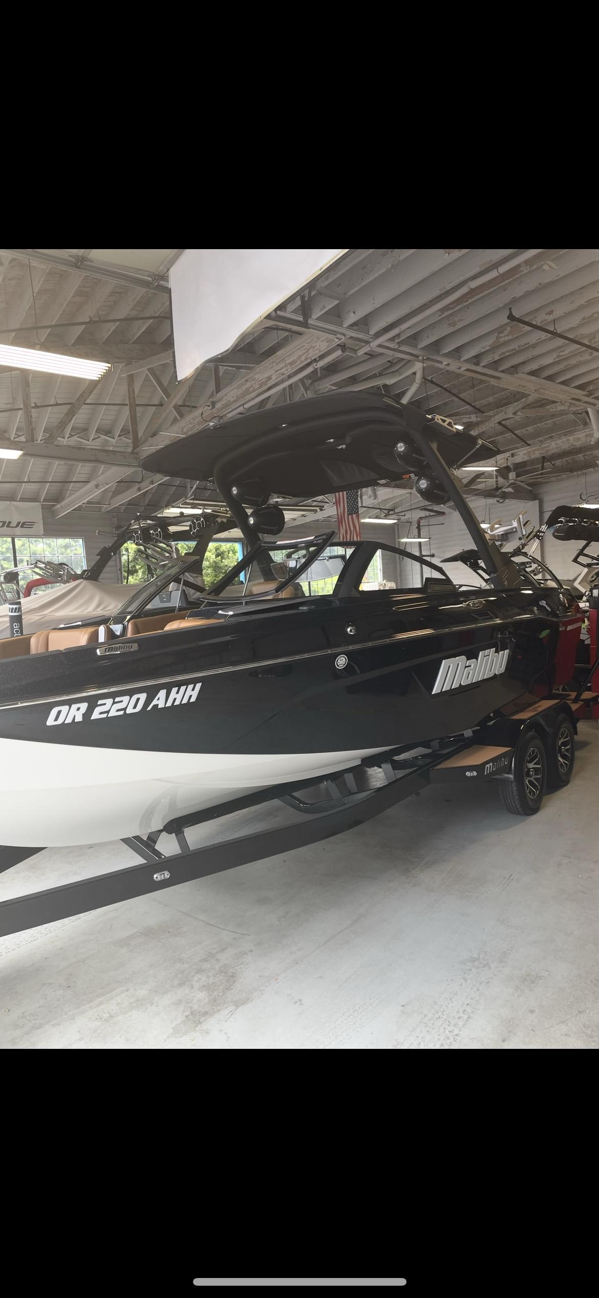 Malibu Wakesetter 23 LSV 2022 Malibu Wakesetter 23 LSV boat in showroom, black and white design.