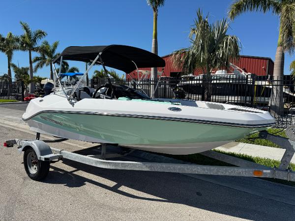 Scarab 165 ID 2022 Scarab 165 ID boat on trailer, parked near palm trees.