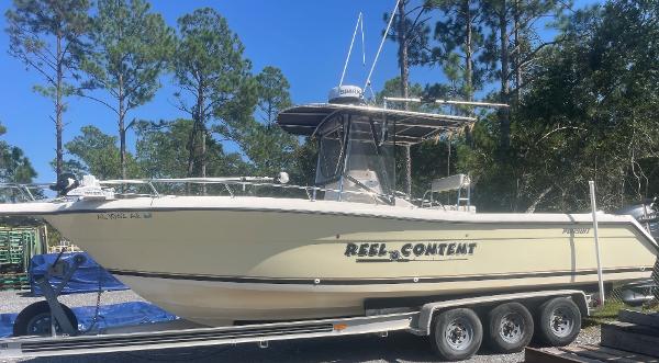 Pursuit 2870 Center Console 2004 Pursuit 2870 Center Console boat on a trailer in a wooded area.