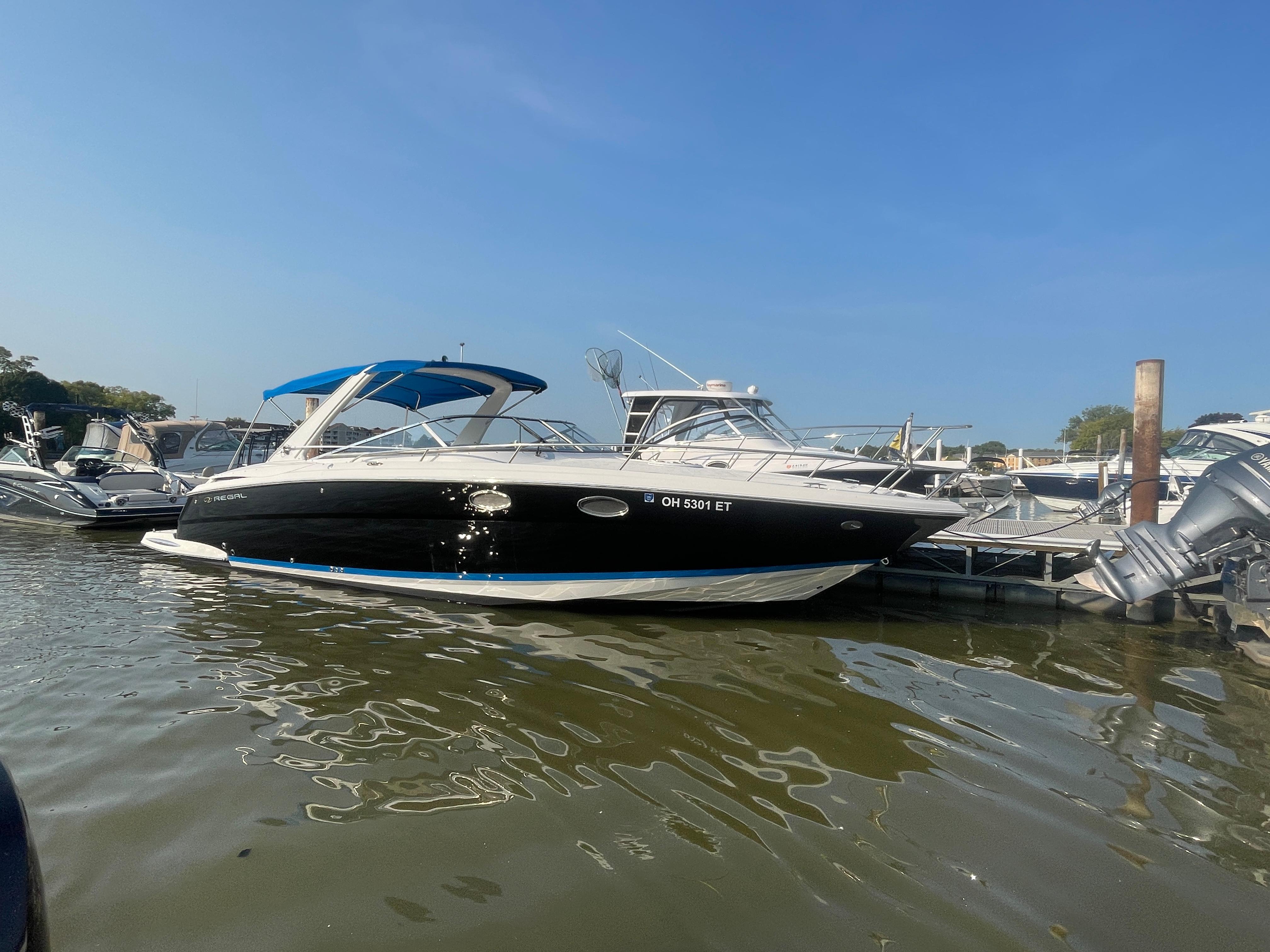 Regal 3350 Sport Cruiser 2005 Regal 3350 Sport Cruiser docked at marina under clear blue sky.