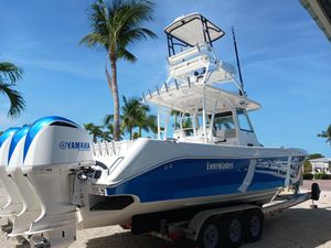 Everglades 355 Center Console 2017 Everglades 355 boat with Yamaha engines on a trailer, surrounded by palm trees.