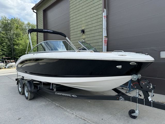 Chaparral 21 SSi 2025 Chaparral 21 SSi boat on trailer, black and white design, parked outdoors.