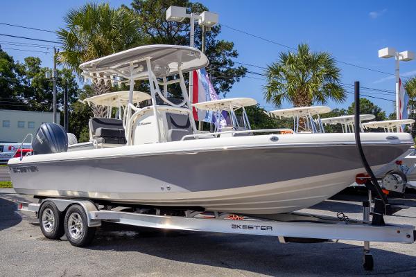 Skeeter SX 2550 2023 Skeeter SX 2550 boat on trailer, parked outdoors with palm trees in background.