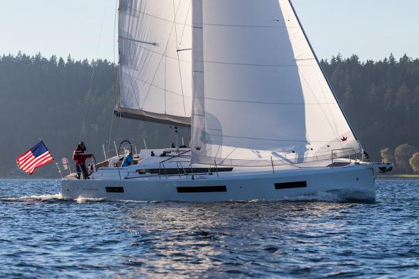 Jeanneau Sun Odyssey 440 2025 Jeanneau Sun Odyssey 440 sailing on a calm lake with an American flag.