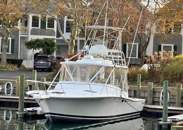 Luhrs Tournament 320 Open 1996 Luhrs Tournament 320 Open boat docked in a marina, surrounded by autumn trees.
