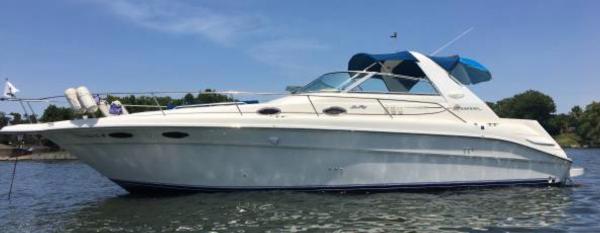 Sea Ray 330 Sundancer 1996 Sea Ray 330 Sundancer boat on water, blue canopy, clear sky.