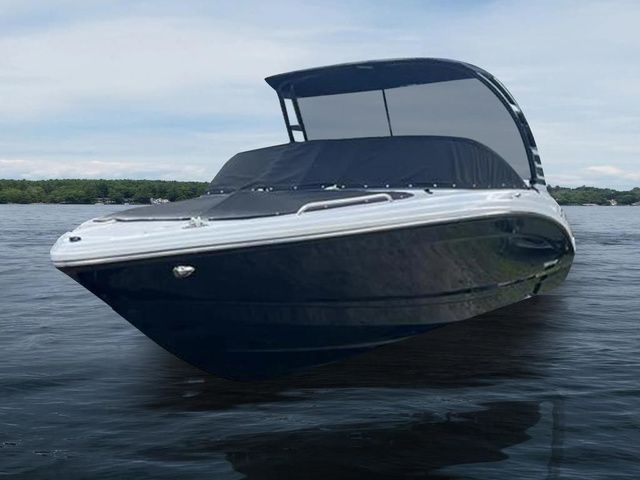 Chaparral 23 SSi 2025 Chaparral 23 SSi boat on calm water, featuring sleek design and modern canopy.