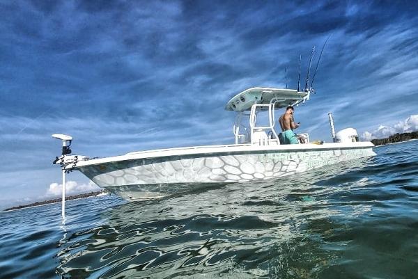Everglades 243 CC 2006 Everglades 243 CC boat on calm water with a fisherman.