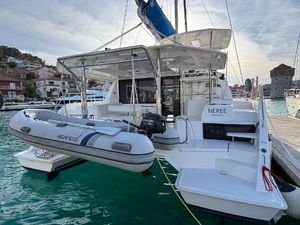 Leopard 40 2019 Leopard 40 catamaran docked with inflatable dinghy, in a scenic marina setting.