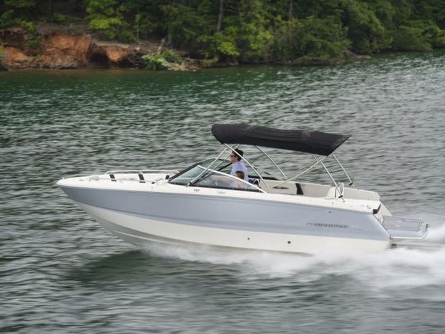 Chaparral 247 SSX 2023 Chaparral 247 SSX boat cruising on a lake with lush green shoreline.