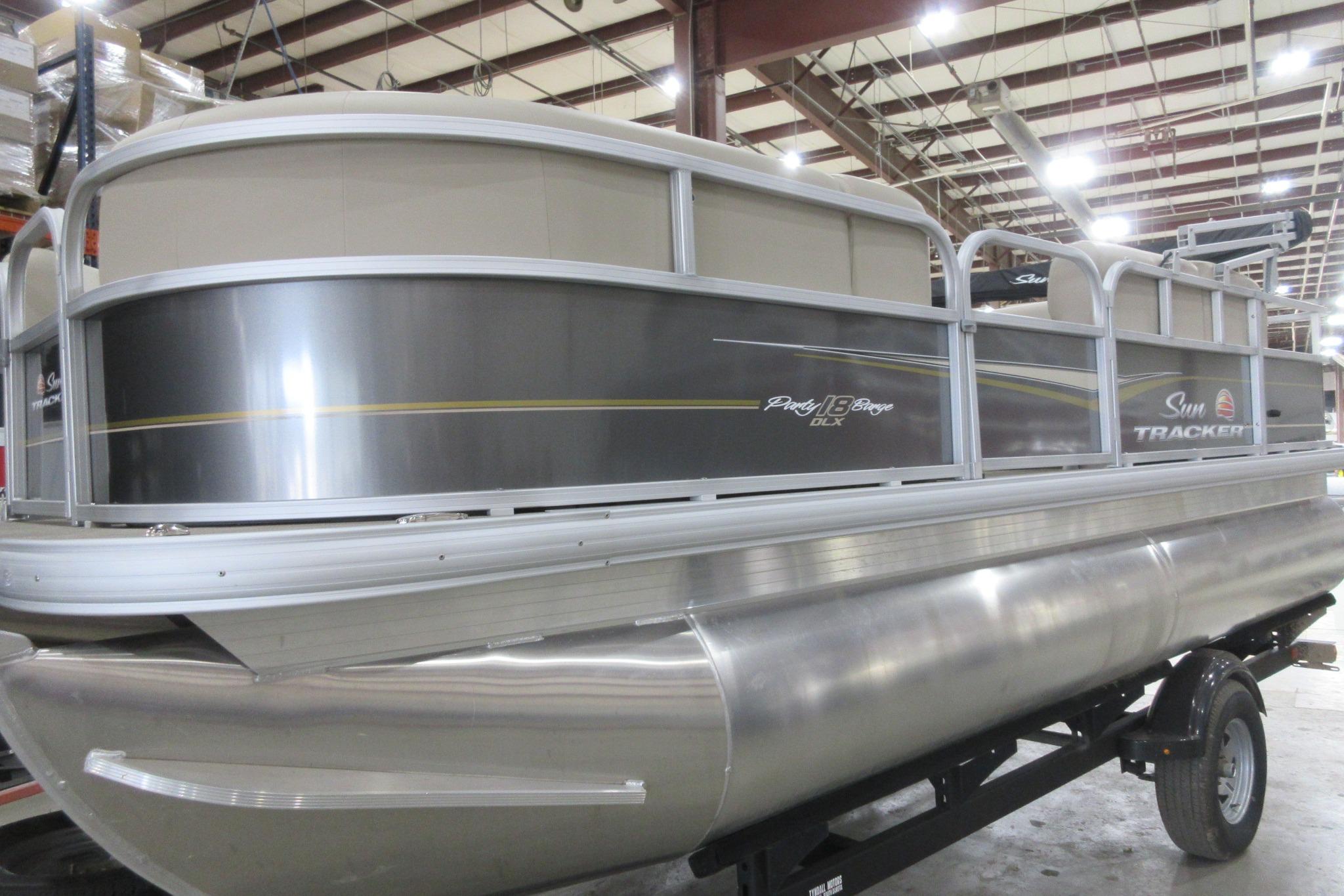 Sun Tracker Party Barge 18 DLX 2024 Sun Tracker Party Barge 18 DLX pontoon boat in a showroom setting.