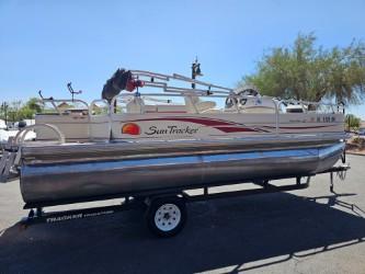 Sun Tracker Fishin' Barge 21 Signature 2008 Sun Tracker Fishin' Barge 21 Signature pontoon boat on trailer, parked outdoors.