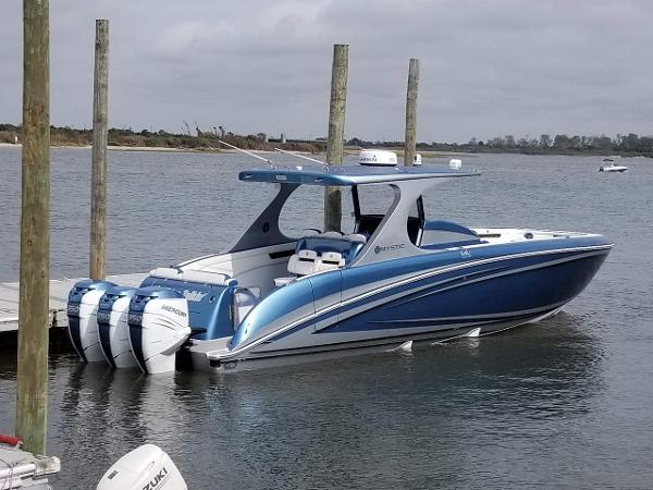 Mystic Powerboats M4200 2018 Mystic Powerboats M4200, blue and white, docked with triple outboard engines.