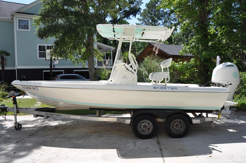 Skeeter SX 210 2017 Skeeter SX 210 boat on trailer, parked in residential driveway.