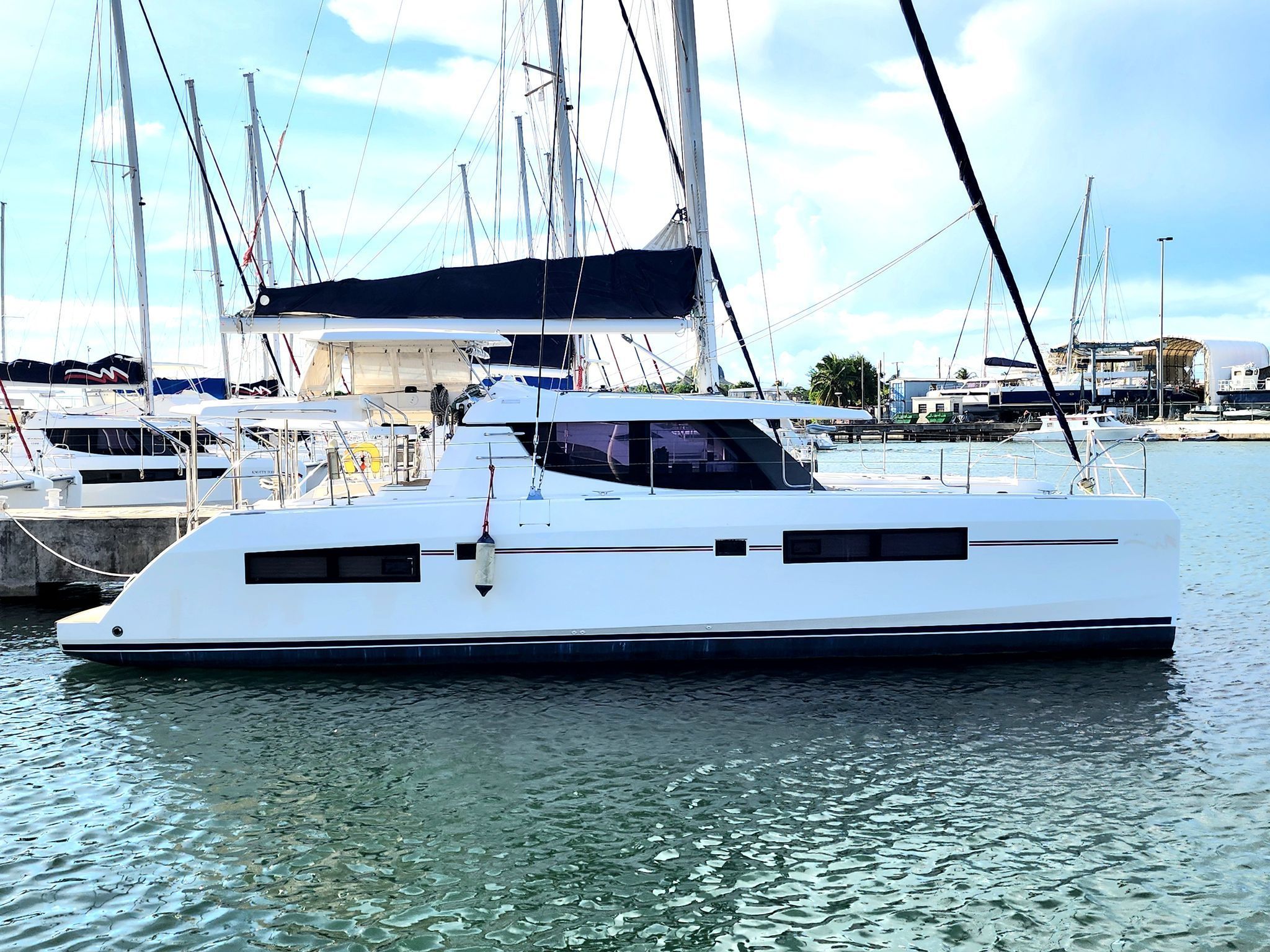 Lion Leopard 4500 2019 Lion Leopard 4500 catamaran docked in marina, clear sky, calm water.