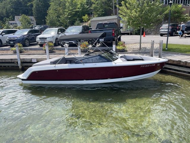 Cobalt CS23 2024 Cobalt CS23 boat docked in clear water near a parking area.