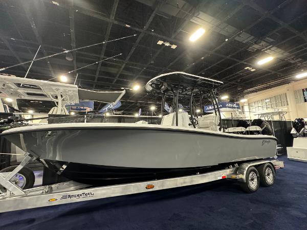 Yellowfin 26 Hybrid 2025 Yellowfin 26 Hybrid boat on trailer at indoor exhibition.