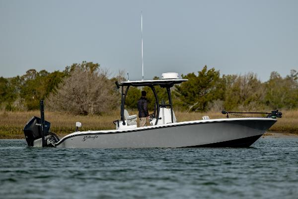 Yellowfin 26 Hybrid 2025 Yellowfin 26 Hybrid boat on calm water, surrounded by trees.